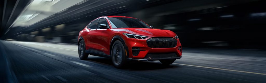 Red Ford Mustang Mach-E speeding through a tunnel.