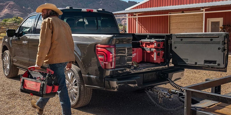 man taking tools out of the back of a ford pick up truck